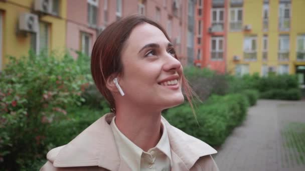 Ήρεμη Καυκάσια γυναίκα διαλογίζεται αναπνέοντας καθαρό αέρα και με αερόποδα στο αυτί της, ακούει μουσική — Αρχείο Βίντεο