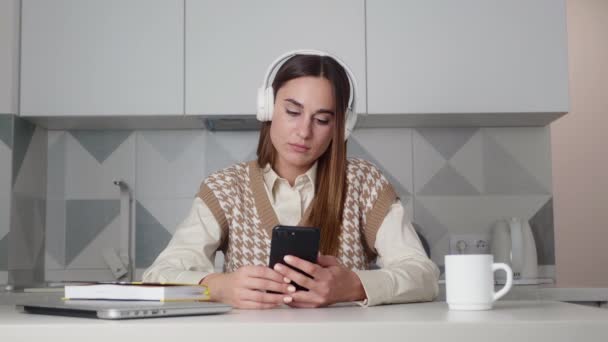 Üzgün genç bir kadın cep telefonundan mesaj okuyor. Kötü haber ve aile sorunları, ilişki sorunları — Stok video