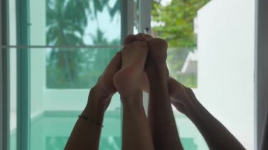 Balayındaki genç bir çiftin bacaklarının silueti. Panoramik pencerelerin ve ormanın zemininde yatıyorlar.