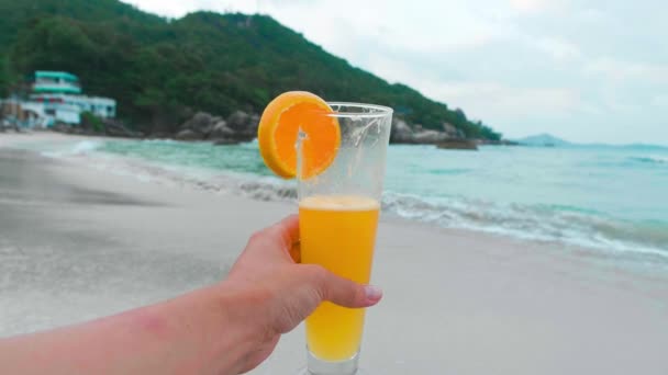 Hembra sosteniendo naranja fresca sobre fondo de olas. Concepto de vacaciones — Vídeo de stock