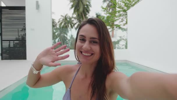 Jovem mulher feliz em férias vlogger acenando mão olhando para webcam falando com câmera nadar em piscina vídeo conferência chamada em reunião de bate-papo virtual com amigo distância social. — Vídeo de Stock