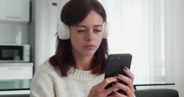 Yüzünde iğrenme, akıllı telefondaki kameraya bakan genç bir kadın.