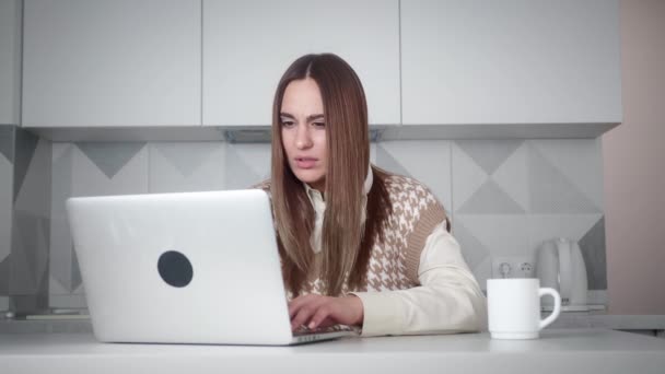 Milenyum iş kadını serbest çalışan kullanıcı tasarımcısı. Evde dizüstü bilgisayarla aynı masada oturuyor. Düşük akü bilgisayar problemleri yaşıyor. — Stok video
