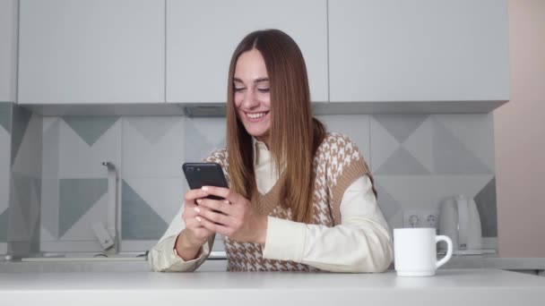Młoda kobieta ogląda na smartfonie w szoku — Wideo stockowe