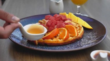 Tatlıyı waffle 'ın üzerine dök, yakın çekim.