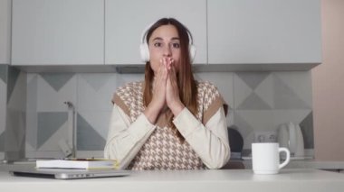 Genç, beyaz, güzel bir kadın kameraya bakıp 