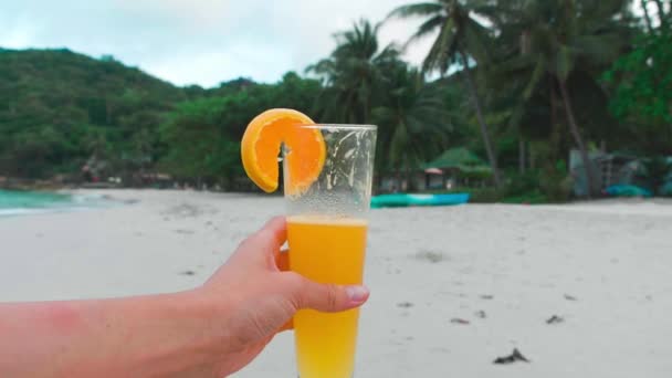 Hembra sosteniendo naranja fresca sobre fondo de olas. Concepto de vacaciones — Vídeos de Stock