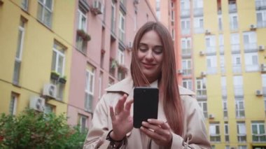Telefon mesajı, şehirde yürüyen mutlu genç bir kadın..