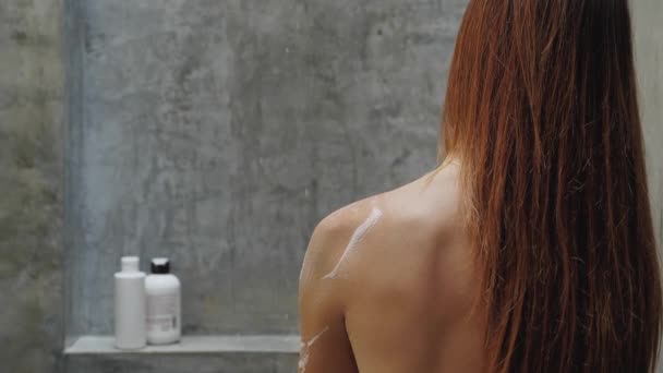 Zadní pohled běloška zpět ve vaně, rameno čistící houbou a mýdlem. Detailní žena zpět ve sprše. — Stock video