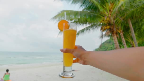 Picnic frente al mar en la orilla del mar playa del océano, jugo de limonada naranja en la mano fondo de verano refrescante bebida, llenar la relajación vacaciones de humor positivo — Vídeo de stock