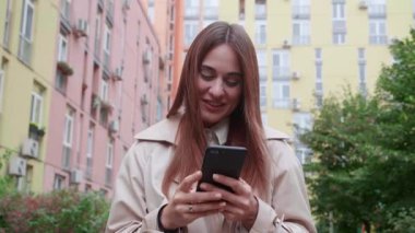 Şehirde cep telefonu olan bir kadın turist. Kamera etrafta uçuyor..