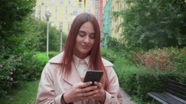 İş kadını akıllı telefonuyla şehirde dolaşıyor, işe gidip geliyor. Sabit çekim
