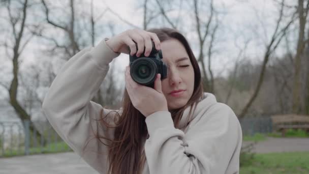 Porträtt av söt kvinna fotograf ta bild sedan titta på kameran ler utomhus — Stockvideo