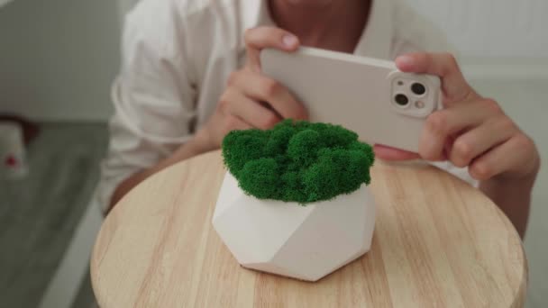 Kadın evde yeşil yosunlu akıllı telefon alçısıyla fotoğraf çekiyor. Makro çekim. — Stok video