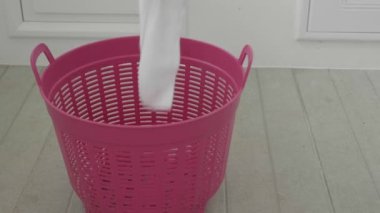 Kirli çamaşırları çamaşır sepetinin içine mutfak arka planına fırlatıyorsun.