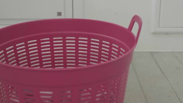 Portret brudne ubrania spadające do różowego kosza na pranie — Wideo stockowe