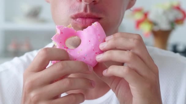 Человек, кусающий аппетитный пончик. нездоровое питание вызывает увеличение веса — стоковое видео