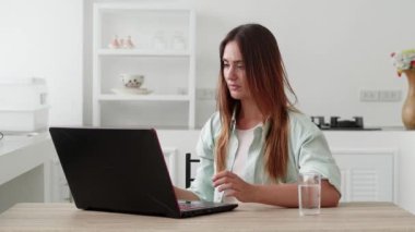 Yirmili yaşlarda genç bir kız dizüstü bilgisayarın modern iç mimarisine şaşırmış görünüyor. İnsanlar yaşam tarzı kavramını hisseder. Şaşırmış görünüyorsun. Elini yüzüne koy..