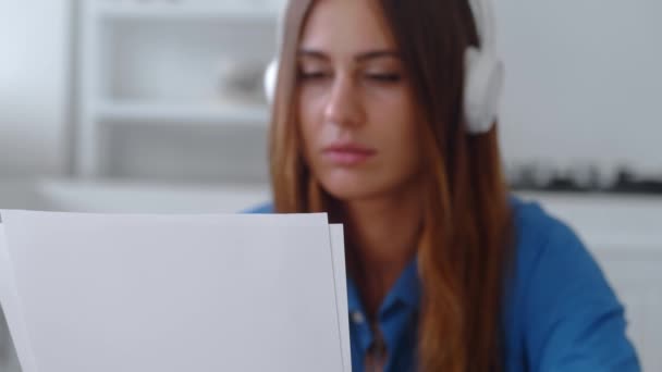Sfrustrowana młoda kobieta czytająca papierowe listy ze złymi wieściami. Koncentracja na papierze — Wideo stockowe