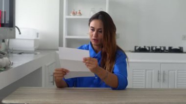 Mavi gömlekli çekici bir kadın mutfak çarşaflarına sarılıp oturur. Mektupta harika haberler okur. Başarıyı kutlar..