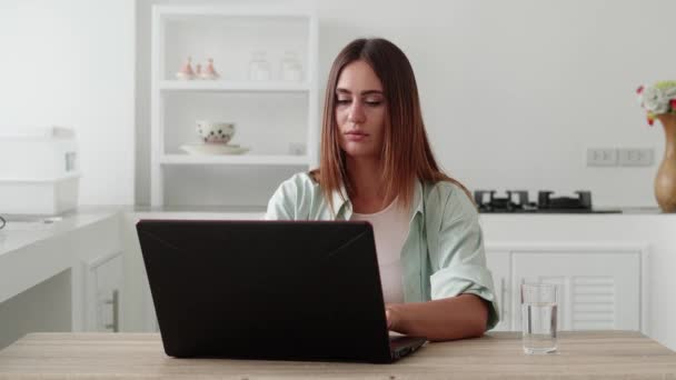 Young woman finishing work on laptop. Satisfied by project accomplishment, task done in time — стоковое видео