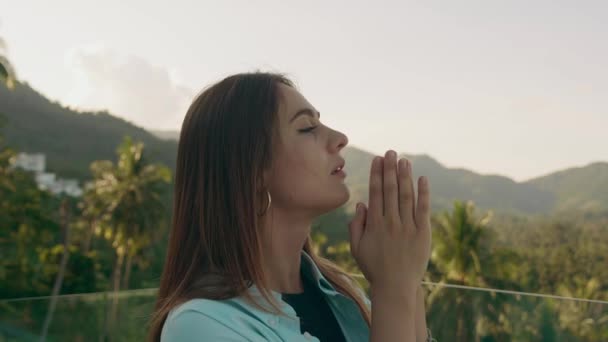 Contemplative young woman looking up to sky with faith and hope. Faithful girl profile face with lens-flare outside — Stockvideo