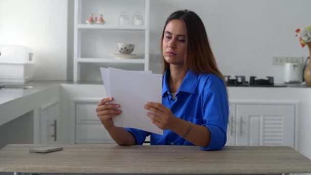 Frustrierte junge Frau liest Zeitungsbrief mit schlechten Nachrichten. — Stockvideo