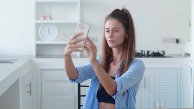 Modern mutfakta selfie çeken kadın portresi. Renkli iç mekan.
