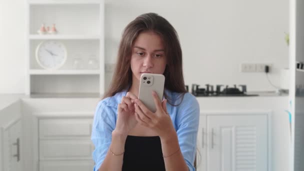 Mutlu Çekici Bir Kız Akıllı Telefona Bakıyor Evde Çene Çalıyor — Stok video