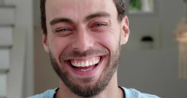 Headshot. Focus on facial expressions of a positive, handsome European guy cheerfully laughing, looking at the camera