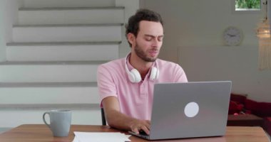 Puzzled man freelancer planning new business project while working remotely on laptop in the comfortable home office