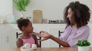 Happy multi-ethnic woman, loving and caring mother gently hugging and stroking her adorable beloved baby girl, at home