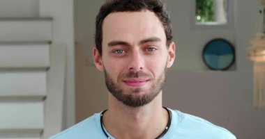 Handsome European guy standing at home interior and spreading into a charming toothy smile while looking at camera.