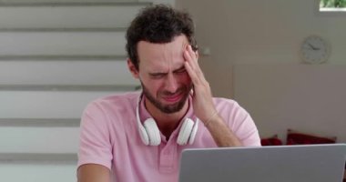 Overworked entrepreneur massages temples while suffering from terrible headache, feeling pain, tension and migraine
