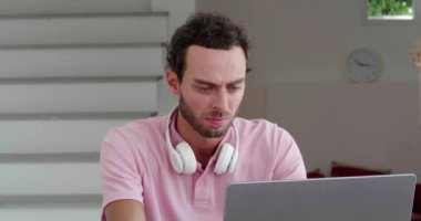 Exhausted male programmer massaging the bridge of his nose, feeling pain due to overwork from hard work at the computer
