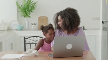 Mom and daughter daughter make video call on laptop. Online communication concept. Connected people across the distance