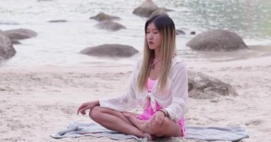 Asian woman practice yoga and medication close the beach.