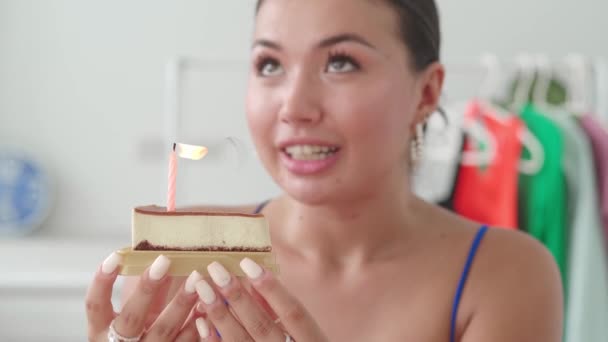 女は願い事をして誕生日ケーキにろうそくを吹き消す — ストック動画