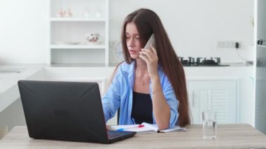 Evde kredi kartıyla alışveriş yapan, cep telefonlu konuşan, internetten sipariş alan çok görevli bir kadın..