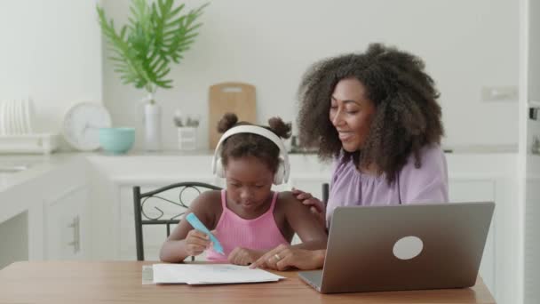 愛するお母さんは彼女の愛らしい娘 スマート1年生をストロークし 宿題をすることに集中し オンラインコースを見て — ストック動画