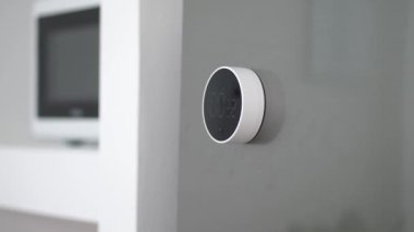 Beyaz duvara yaslanmış, minimal siyah beyaz alarm saatinin kronometre veya zamanlayıcısını kapatmaya yakın plan.