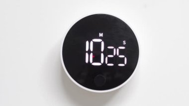 Siyah minimalist zamanlayıcı beyaz duvarda, zamanı tersine çeviriyor. Geri sayım başladı. Hızlı akan zaman kavramı.