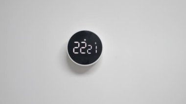 Duvara monte edilmiş, minimalist dizaynlı siyah beyaz saat, ters zaman tepkisi, beyaz bir duvara asılı.