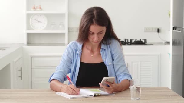 Νεαρή Λευκή Γυναίκα Κάθεται Ένα Τραπέζι Κοιτάζοντας Smartphone Της Και — Αρχείο Βίντεο