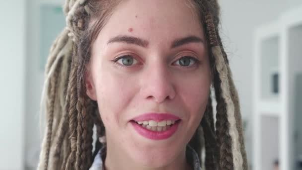 Zbliżenie Portret Radosnej Młodej Kobiety Dredami Stojącej Samotnie Nowoczesnym Wnętrzu — Wideo stockowe