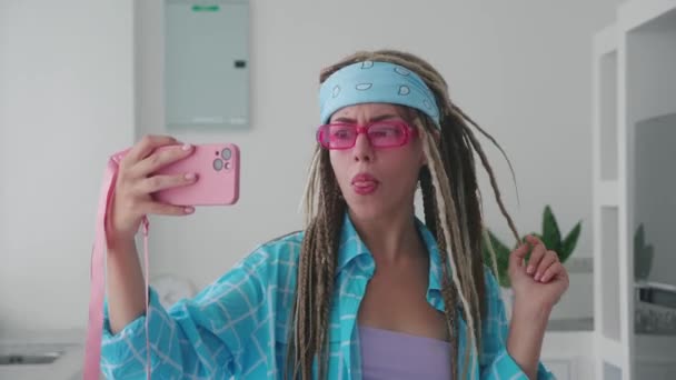 在现代室内环境的社交网络上 生动的年轻女孩穿着毛衫 穿着自拍的衣服 在手机上拍照 — 图库视频影像