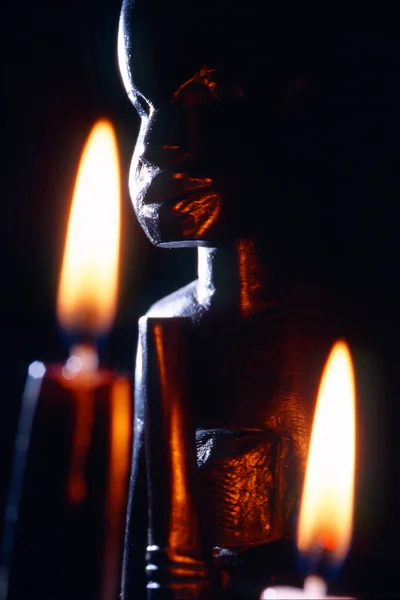 Oscuro Primer Plano Una Estatua Africana Con Dos Candeles Ardientes Fotos De Stock