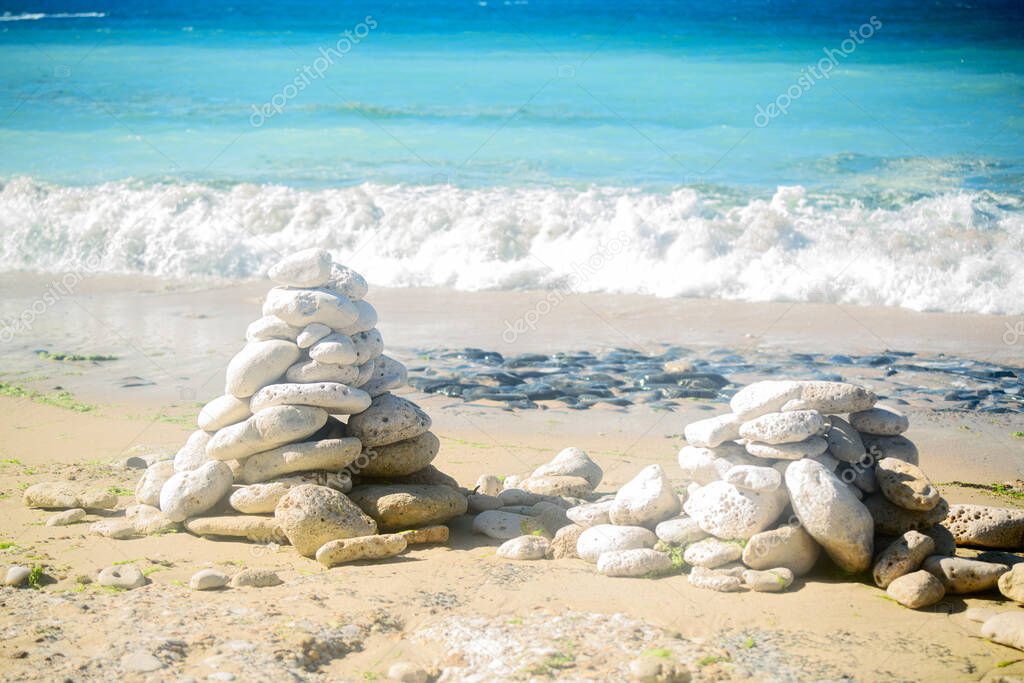 Pile of stone on the beach on the lighthouse Phare des Baleines on the isle of ile de Re in France on a sunny summerday