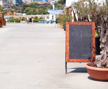 Restoranın yanında ahşap çerçeveli karatahta menüsü, afiş için alanı kopyala. Tebeşir tahtası restoran menüsü modeli.