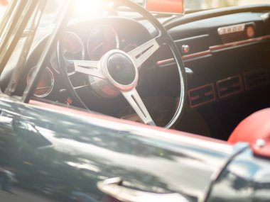 Klasik eski model Cabrio araba. İçi kırmızı deri. Güneşe karşı klasik direksiyon. Yaz titreşimleri.